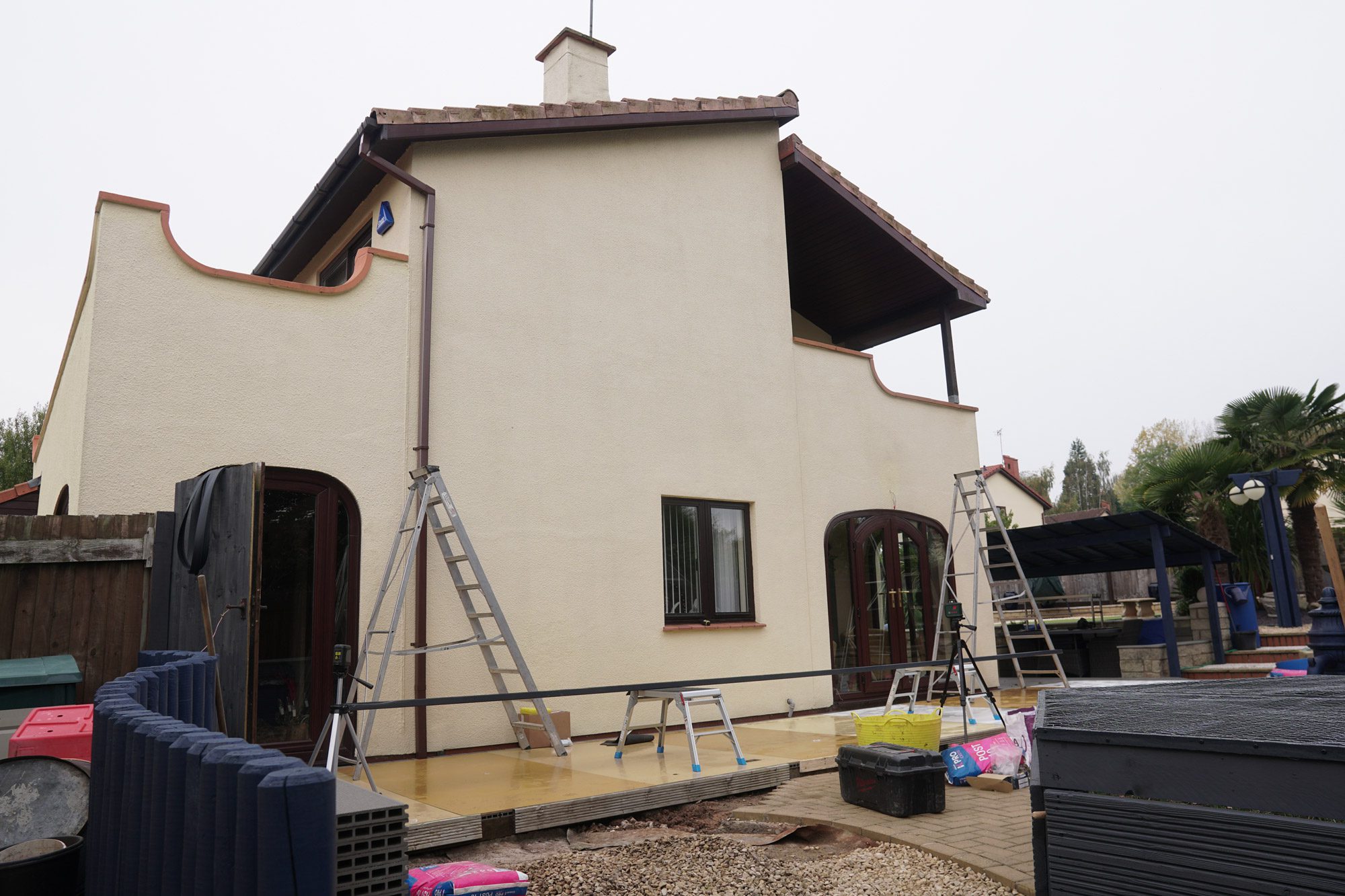 Concrete pad foundation being prepared at veranda post location during patio installation