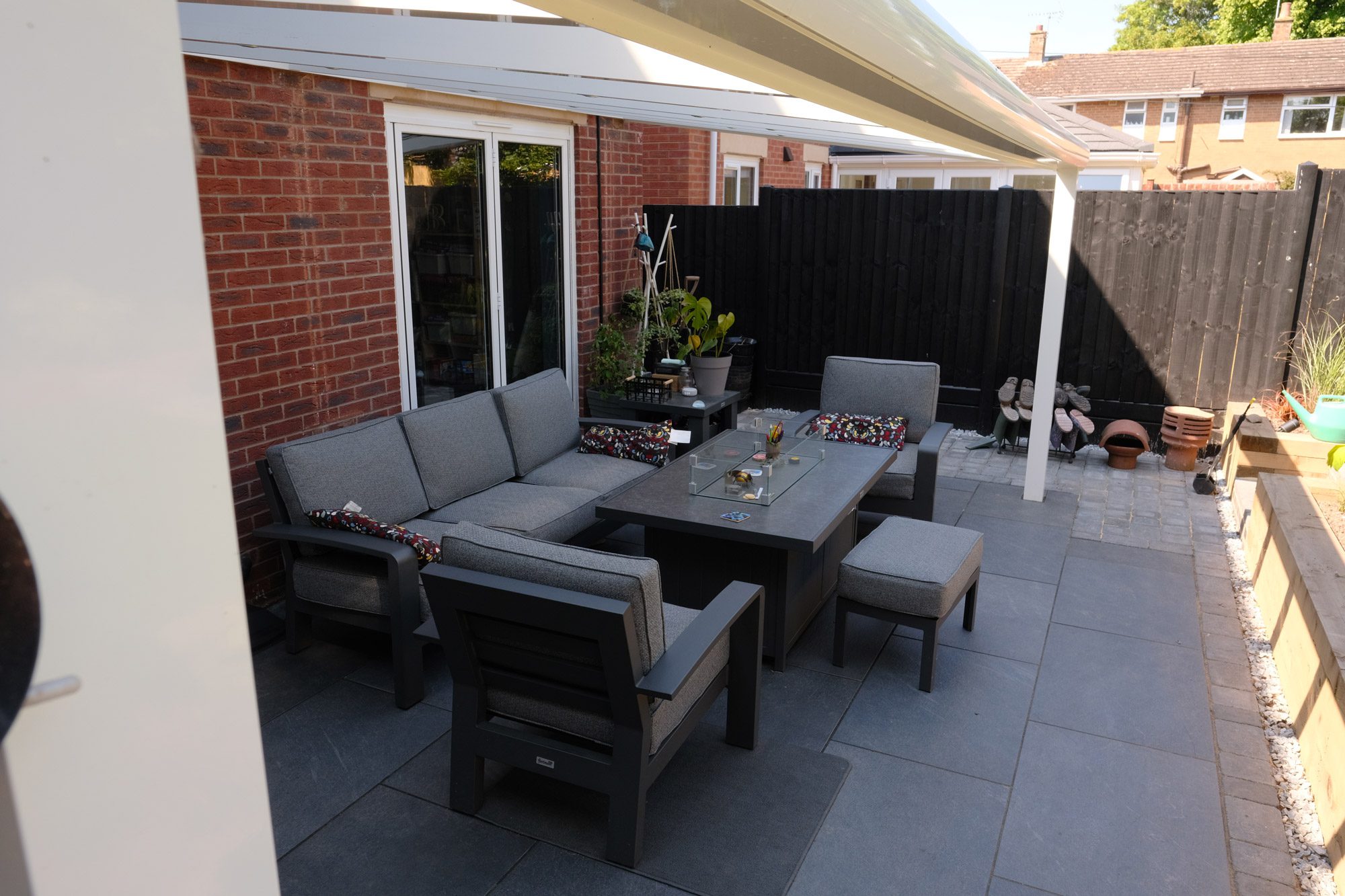 ACO drainage channel installed at edge of patio beneath glass veranda to direct rainwater away from property