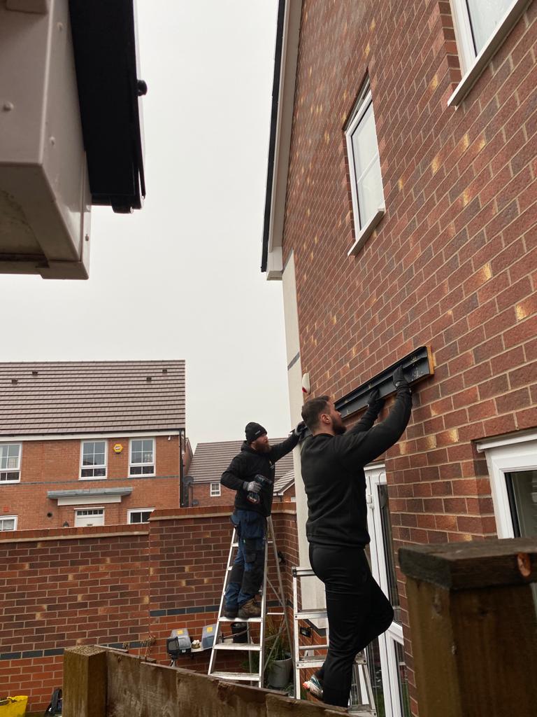 Fleming Verandas installer working alongside landscaper during patio and veranda installation